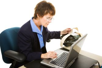 A court reporter using a stenotype machine and laptop to create verbatim records of courtroom proceedings.