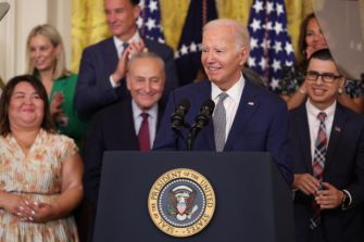 President Biden speaking at an event, surrounded by supporters, announcing new immigration regulations.