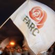 A person holding a white flag featuring the FARC logo during a protest or demonstration. A person holding a white flag featuring the FARC logo during a protest or demonstration.