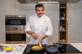 Celebrity chef Todd English cooking in a modern kitchen setting.