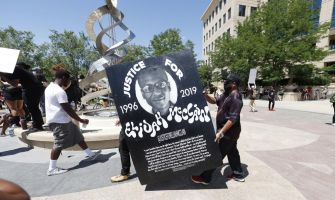 A protester holds a sign reading "Justice for Elijah McClain" during a demonstration.
