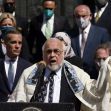 A group of individuals, including a speaker in traditional Jewish attire, participate in a rally addressing rising antisemitism and hate crimes against the Jewish community. A group of individuals, including a speaker in traditional Jewish attire, participate in a rally addressing rising antisemitism and hate crimes against the Jewish community.