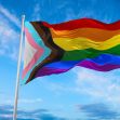 Pride flag waving against a blue sky, representing LGBTQ+ rights and inclusion. Pride flag waving against a blue sky, representing LGBTQ+ rights and inclusion.