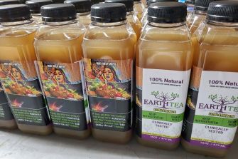 Bottles of Earth Tea displayed on a table, marketed as a natural remedy.