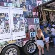Fans line up at a merchandise truck for Taylor Swift's Eras Tour, showcasing various items associated with the concert. Fans line up at a merchandise truck for Taylor Swift's Eras Tour, showcasing various items associated with the concert.
