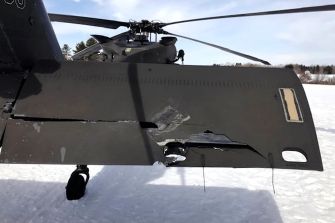 Damage to the tail end of a Black Hawk helicopter after a snowmobile collision.