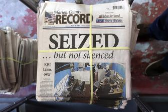 Front page of the Marion County Record newspaper with the headline "SEIZED ... but not silenced" and a photo of a police raid in the newsroom.