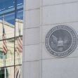 Seal of the U.S. Securities and Exchange Commission on a building with reflections of American flags in the windows. Seal of the U.S. Securities and Exchange Commission on a building with reflections of American flags in the windows.
