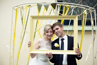 A happy couple posing together in a decorative frame on their wedding day.