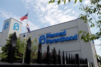 Exterior of a Planned Parenthood facility with an American flag flying nearby.