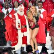 Mariah Carey performs during a holiday event surrounded by a choir and Santa Claus. Mariah Carey performs during a holiday event surrounded by a choir and Santa Claus.
