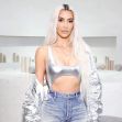 Kim Kardashian poses in a silver outfit with a minimalist background. Kim Kardashian poses in a silver outfit with a minimalist background.