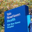 Sign for Yale New Haven Health and Yale New Haven Hospital with autumn foliage in the background. Sign for Yale New Haven Health and Yale New Haven Hospital with autumn foliage in the background.