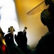 A healthcare worker in personal protective equipment holding test tubes while performing a COVID-19 test. A healthcare worker in personal protective equipment holding test tubes while performing a COVID-19 test.
