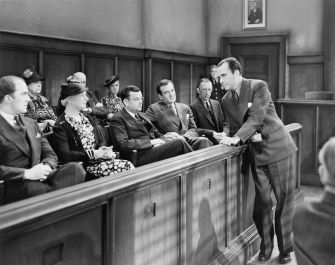 A black and white court scene featuring a judge, jurors, and an attorney speaking to the jury in a courtroom.