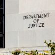 Signage of the U.S. Department of Justice on the exterior of a building. Signage of the U.S. Department of Justice on the exterior of a building.