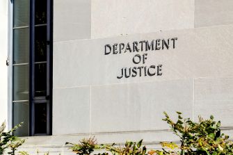 Signage of the U.S. Department of Justice on the exterior of a building.