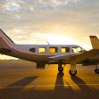 A small Piper PA28 aircraft on the runway at sunset. A small Piper PA28 aircraft on the runway at sunset.