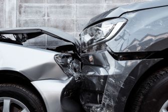 Close-up of two cars that have been involved in a front-end collision, highlighting the damage to the front of each vehicle.