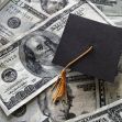 Graduation cap on top of a pile of one-hundred dollar bills representing student loans. Graduation cap on top of a pile of one-hundred dollar bills representing student loans.