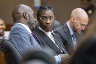 Young Thug sitting in court with his legal team during a trial session.
