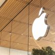Apple logo on the exterior of an Apple Store, featuring a modern design with wooden ceiling and glass reflections. Apple logo on the exterior of an Apple Store, featuring a modern design with wooden ceiling and glass reflections.