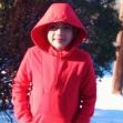 A young boy wearing a red hoodie standing outdoors in a snowy landscape. A young boy wearing a red hoodie standing outdoors in a snowy landscape.