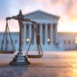 A scale of justice in front of the U.S. Supreme Court building at sunset. A scale of justice in front of the U.S. Supreme Court building at sunset.