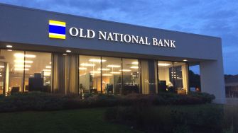Exterior view of Old National Bank building at night, featuring the bank's logo.