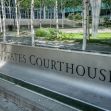 United States Courthouse sign set amidst trees and greenery. United States Courthouse sign set amidst trees and greenery.