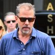 Hunter Biden walking outside wearing sunglasses, accompanied by a woman in the background. Hunter Biden walking outside wearing sunglasses, accompanied by a woman in the background.
