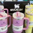 A display of colorful Stanley Quencher tumblers in various sizes, with a logo prominently featured in the background. A display of colorful Stanley Quencher tumblers in various sizes, with a logo prominently featured in the background.