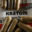 Capsules of kratom on a package labeled with the product name and description. Capsules of kratom on a package labeled with the product name and description.