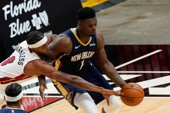 Zion Williamson in action during a basketball game, competing for possession of the ball.