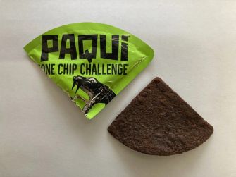 Image of the Paqui One Chip Challenge packaging next to the chip itself.