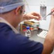 A medical professional handling laboratory equipment in a fertility clinic setting. A medical professional handling laboratory equipment in a fertility clinic setting.