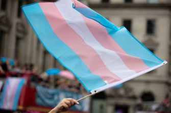 Transgender pride flag being waved at a public event.
