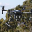 A police drone in flight against a backdrop of trees. A police drone in flight against a backdrop of trees.