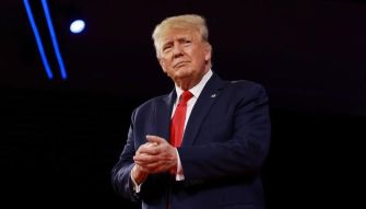 Former President Donald Trump at a public event, appearing contemplative and engaged.