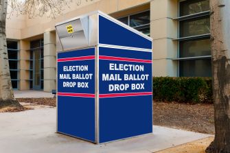 A blue mail ballot drop box with the text "ELECTION MAIL BALLOT DROP BOX" displayed prominently.
