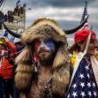 A man wearing a Viking-style headdress and face paint stands among a crowd, holding a spear with an American flag attached, during the Capitol riot on January 6. A man wearing a Viking-style headdress and face paint stands among a crowd, holding a spear with an American flag attached, during the Capitol riot on January 6.
