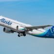 An Alaska Airlines plane taking off against a blue sky. An Alaska Airlines plane taking off against a blue sky.