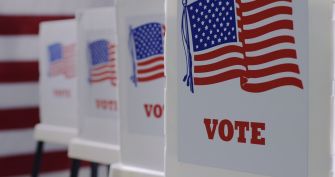 Voting booths with American flags and the word "VOTE" displayed prominently.