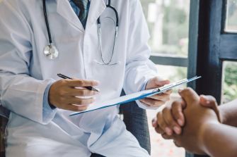 A doctor discussing treatment options with a patient in a clinical setting.
