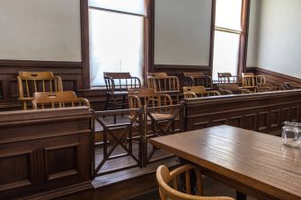 Empty jury box with wooden chairs in a courtroom setting.