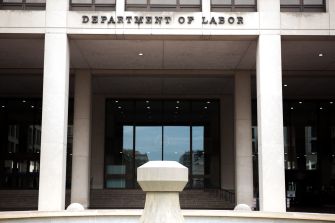 Facade of the U.S. Department of Labor building with entrance and fountain in view.