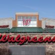 Walgreens store front with prominent signage against a blue sky. Walgreens store front with prominent signage against a blue sky.