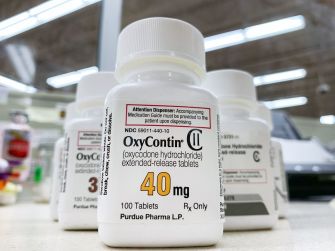 Bottle of OxyContin medication on a pharmacy shelf, labeled as containing 40 mg extended-release tablets.