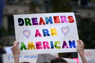 A protest sign that reads "DREAMERS ARE AMERICAN" in colorful letters.