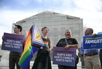 Protesters holding signs advocating against conversion therapy for minors outside the Supreme Court.